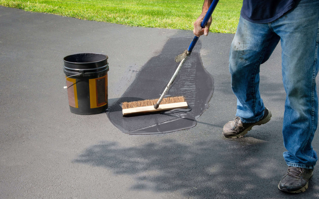 Worker Sealing Driveway